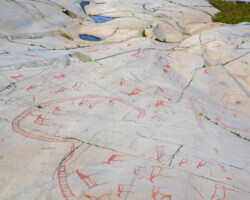 The red paint was added later to make the rock carvings easier to see.